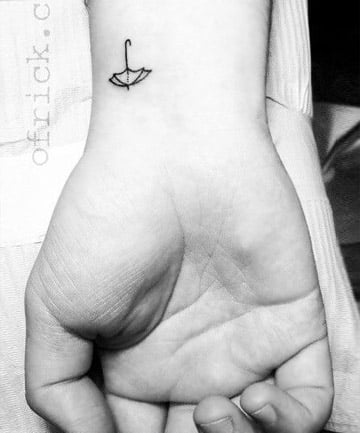 Tiny ankle tattoo of a sailboat and three stars by