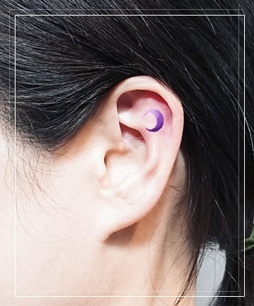 Crescent moon tattoo on the back of the right ear